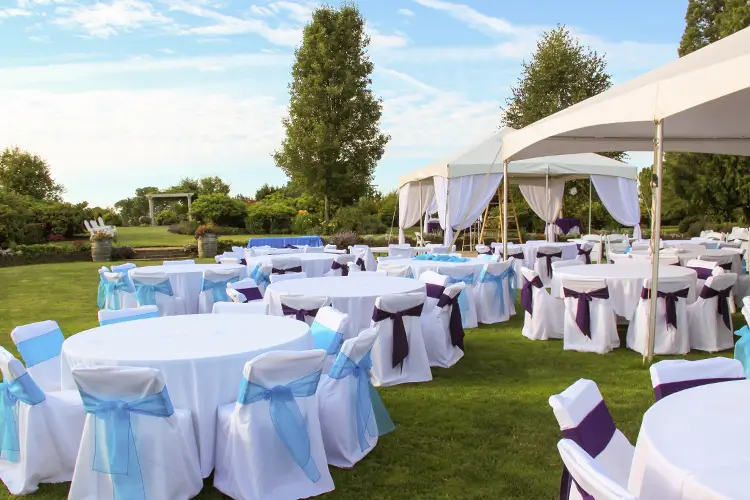 A view of the Wooden Shoe Gardens space for events shows tables & tent decorated for a formal event